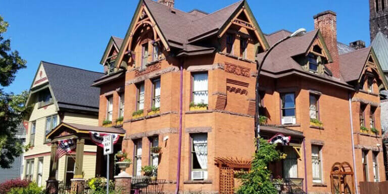 The brick exterior of Buffalo Harmony house as seen on a clear sunny day.