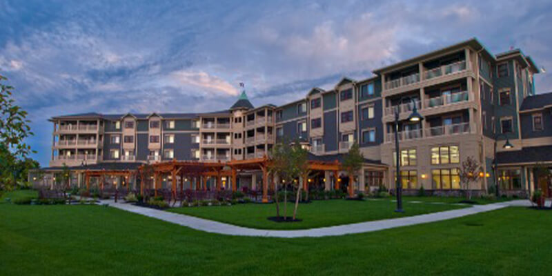 The exterior of the 1000 Islands Harbor Hotel with illuminated rooms during the evening